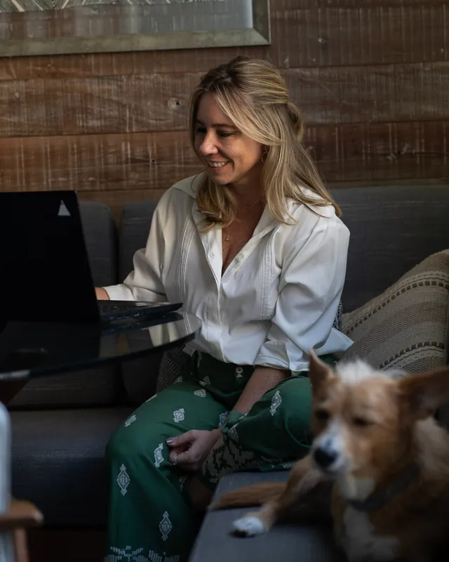 Milena Alves de Carvalho sorrindo em frente ao notebook, em atendimento online